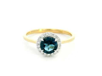 18K yellow gold ring with a 0.92-carat round-cut London blue topaz framed by a 0.15-carat diamond halo – elegant fine jewelry.