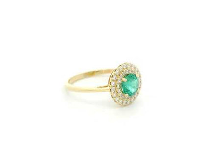 18K yellow gold emerald and diamond halo ring with round emerald center, luxury fine jewelry by Emirates Diamonds.