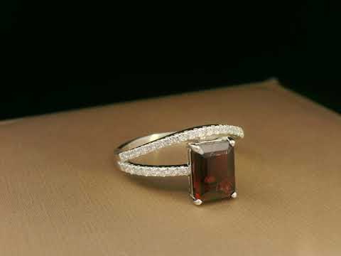 18K white gold bypass ring with emerald-cut garnet and diamond accents