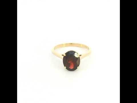 Oval garnet solitaire ring in 18K yellow gold