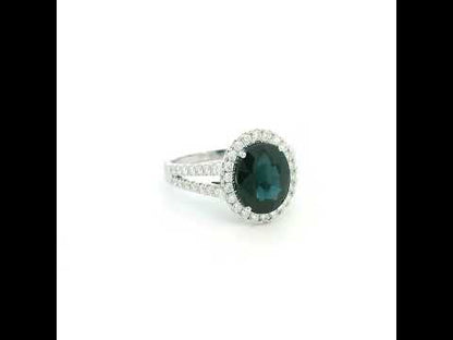 Oval blue sapphire halo ring in 18K white gold with diamond split shank band