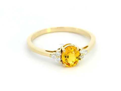 18K yellow gold ring with a 0.80-carat oval yellow sapphire and 0.09-carat diamond accents in a three-stone setting, elegant and timeless design.