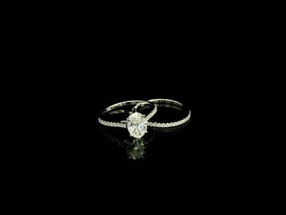 Oval cut diamond bridal set in 18K white gold featuring a GIA certified 1.50 carat natural oval diamond with matching diamond wedding band.