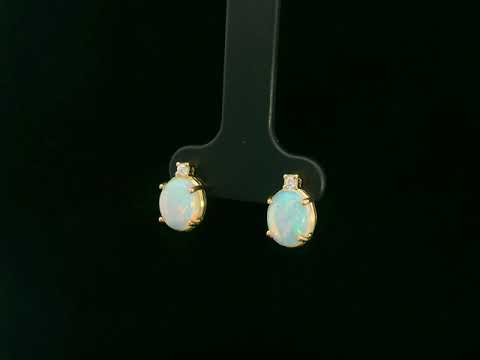 18K yellow gold opal and diamond stud earrings with oval opals and subtle diamond accents, luxury fine jewelry by Emirates Diamonds.