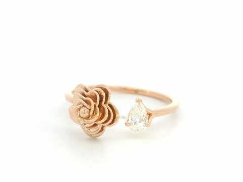 18K rose gold bypass ring featuring a 0.18 carat pear-cut diamond with sculpted floral gold detail – Emirates Diamonds