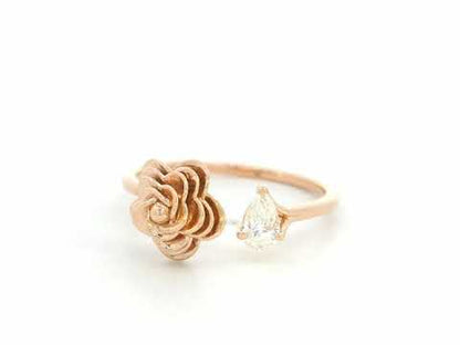 18K rose gold bypass ring featuring a 0.18 carat pear-cut diamond with sculpted floral gold detail – Emirates Diamonds