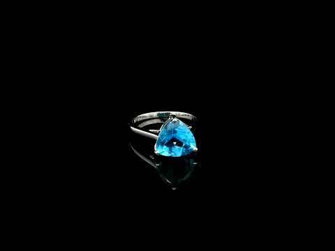 18K white gold solitaire ring featuring a 4.57 carat natural trillion-cut blue topaz in a contemporary three-prong setting.