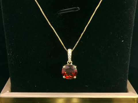 18K gold pendant with a 2.03ct deep red garnet in a four-prong setting, accented by 0.06ct diamonds on the bail. Chain not included.