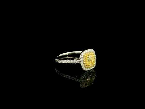 18K white gold engagement ring featuring a 0.58 carat GIA certified Fancy Yellow cushion cut diamond with SI1 clarity, surrounded by yellow and white diamond double halos with a diamond-set band.
