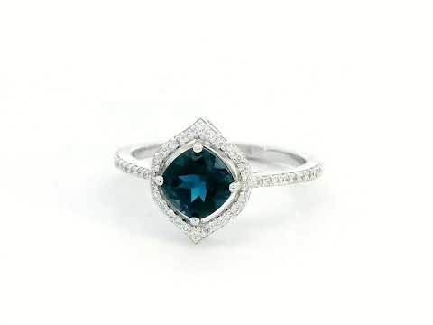 Cushion-cut London Blue Topaz ring with diamond halo and pavé diamond band in 18K gold

