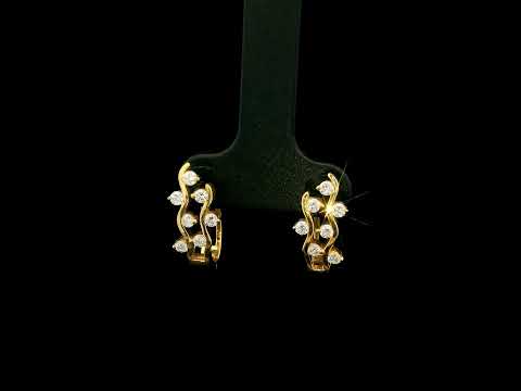 18K yellow gold diamond wave hoop earrings featuring flowing open gold curves with scattered round brilliant diamonds.