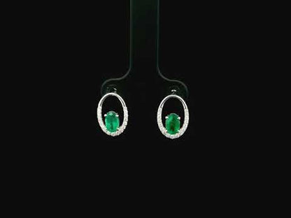 Emerald and diamond halo stud earrings in 18K white gold featuring 0.92 carat emeralds and 0.20 carat diamonds by Emirates Diamonds.
