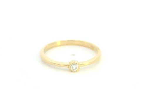18K yellow gold bezel set diamond ring featuring a 0.07 carat natural round brilliant diamond in a minimalist solitaire design.