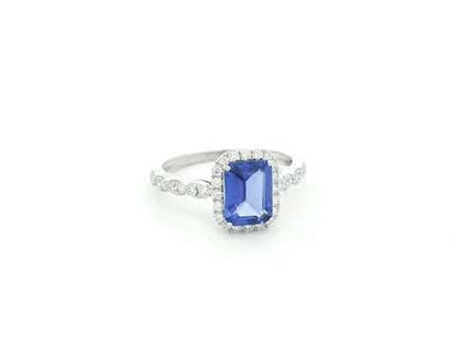 Emerald cut tanzanite halo ring in 18K white gold with marquise diamond band
