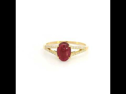Oval cabochon ruby and diamond ring in 18K yellow gold with diamond-set split shoulders.