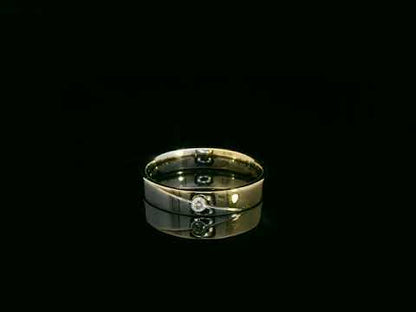 Unisex 18K two-tone wedding band with 0.03 carat bezel-set diamond, sleek modern flat profile