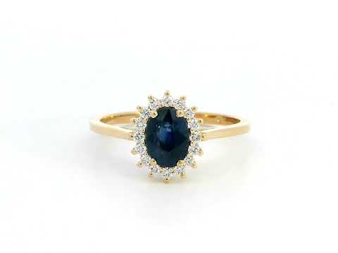 Oval Blue Sapphire and diamond halo ring in 18K gold, featuring a 1.02ct royal blue gemstone surrounded by 0.19ct round diamonds. Elegant fine jewelry inspired by Princess Diana’s iconic ring.