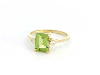 18K gold emerald-cut Peridot ring with 0.07ct diamond accents, featuring a vibrant 1.53ct Peridot centerpiece.