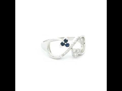 Blue sapphire and diamond infinity ring in 18K white gold with three round blue sapphires and diamond detailing.