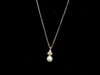 18K rose gold freshwater pearl pendant necklace featuring a white freshwater pearl suspended beneath a natural diamond cluster.