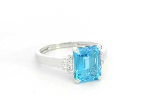 18K white gold emerald-cut Swiss blue topaz ring with diamond side accents by Emirates Diamonds