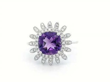 Elegant amethyst and diamond sunburst ring in 18K gold, featuring a 1.30-carat cushion-cut amethyst and 0.17-carat diamonds in a radiant halo design.