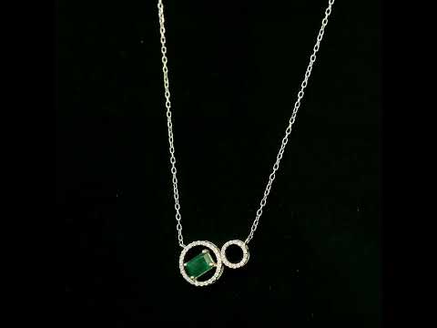Emerald and diamond necklace in 18K white gold featuring a rectangular emerald-cut green gemstone inside a diamond circle, connected to a smaller diamond-set circle.