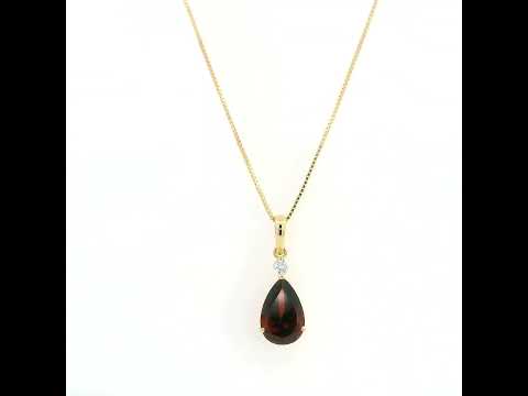 Pear shaped garnet and diamond pendant in 18K yellow gold with a single round diamond accent.