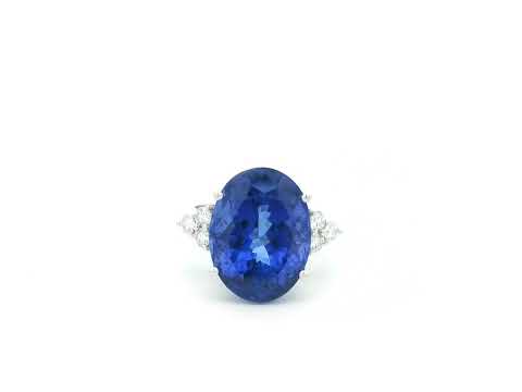 Natural 14.12 carat oval tanzanite and diamond ring in 18K white gold with natural diamond shoulders.
