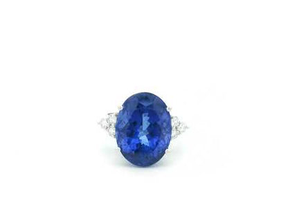 Natural 14.12 carat oval tanzanite and diamond ring in 18K white gold with natural diamond shoulders.