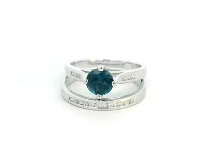 Elegant 18K White Gold London Blue Topaz and Diamond Bridal Ring Set featuring a 0.96-carat round-cut topaz and 0.18-carat diamonds on an engagement ring and matching wedding band