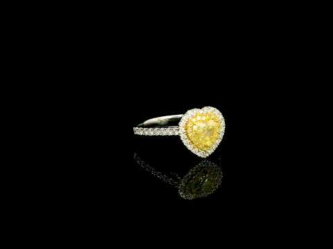18K white gold engagement ring featuring a 0.73 carat GIA certified heart shaped Fancy Yellow diamond with VS2 clarity, surrounded by a yellow diamond halo, white diamond outer halo, and diamond set band.