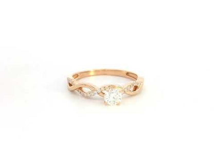 0.32 carat diamond solitaire twist engagement ring in 18K rose gold with pavé band by Emirates Diamonds