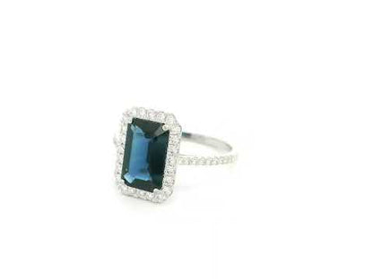 Emerald cut blue sapphire halo ring in 18K white gold with diamond accents Emirates Diamonds