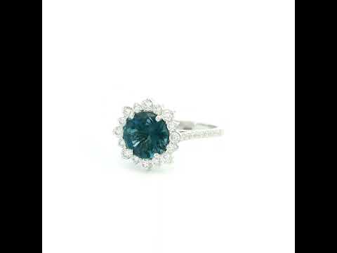 18K white gold London Blue Topaz halo ring featuring a 2.04 Carat round natural topaz surrounded by a sparkling natural diamond halo.