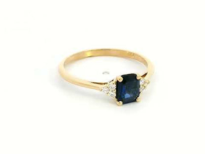 Petite 18K gold ring featuring a 0.68-carat emerald-cut blue sapphire, accented by 0.08-carat diamonds. Perfect for stacking or wearing alone.