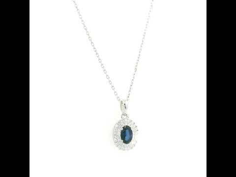 Blue sapphire and diamond halo pendant in 18K white gold with an oval sapphire surrounded by two rows of round diamonds