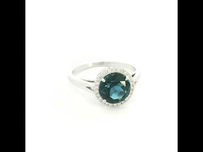 18K white gold ring with a deep blue London blue topaz surrounded by round diamonds and a split-shoulder band.