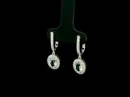 18K White Gold Aquamarine Drop Earrings featuring 1.50 carats of natural oval aquamarines surrounded by diamond halos with diamond huggie hoops and 0.48 carat natural diamonds.