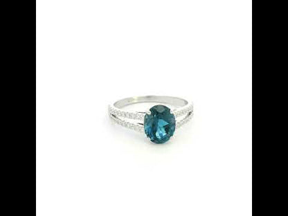 Natural London Blue Topaz ring in 18K white gold featuring a 2.22 carat oval London Blue Topaz with a split shank and 0.36 carat natural diamond band.