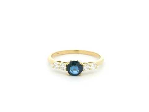 Natural Blue Sapphire and Diamond Ring in 18K Yellow Gold featuring a 0.65 carat round blue sapphire with 0.25 carat natural diamond side stones.