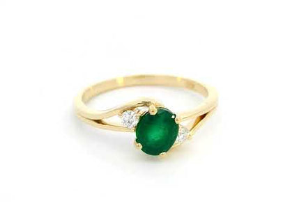 This 18K yellow gold ring features a mesmerizing 0.75-carat round-cut emerald, accented by 0.10 carat of sparkling diamonds on a delicate split-shank band. The vibrant green hue of the emerald beautifully contrasts with the warm gold setting, while the diamonds add brilliance and sophistication. A refined and timeless piece, perfect for marking special moments or as a meaningful gift for May birthdays.