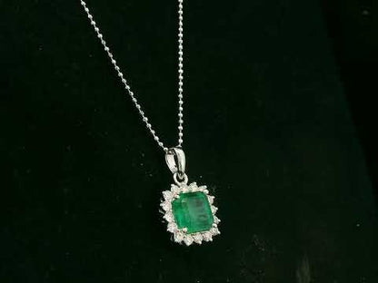 18K white gold emerald and diamond halo pendant by Emirates Diamonds