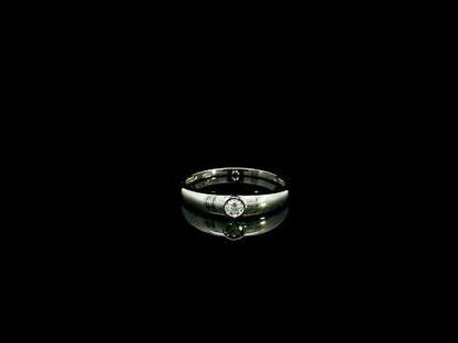 18K white gold bezel set solitaire diamond ring featuring a 0.11 carat natural round brilliant diamond with a smooth polished band.