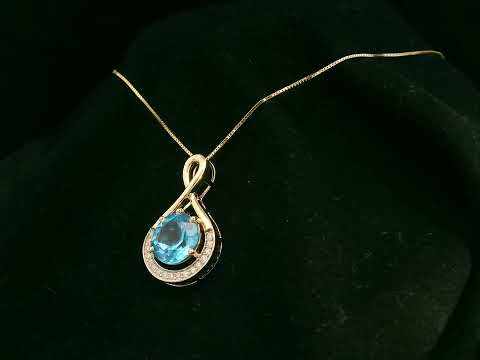 18k yellow gold pendant with 2.30 carat Swiss blue topaz center, diamond halo, and infinity-style bale