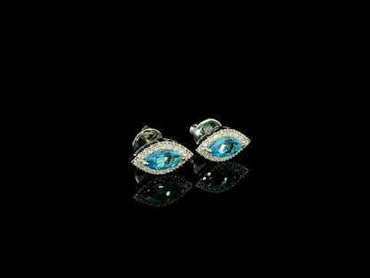 18K white gold blue topaz and diamond halo stud earrings featuring marquise-shaped blue topaz gemstones surrounded by round diamonds in an eye-shaped design.