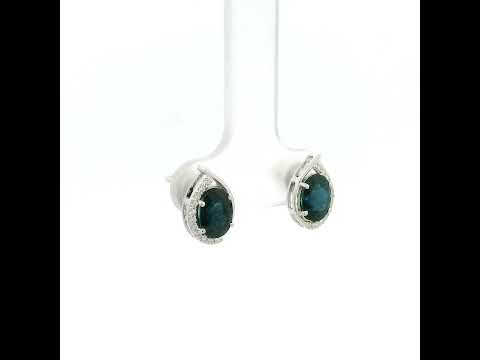 Oval blue sapphire and diamond stud earrings in 18K white gold with curved diamond accents