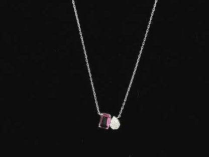 18K white gold pendant necklace featuring a 0.63 carat emerald cut pink sapphire paired with a 0.07 carat pear shaped diamond.