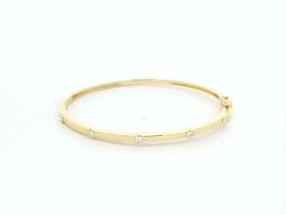 Minimal diamond bangle bracelet in 18K yellow gold with bezel-set natural diamonds