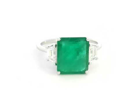 Emerald-cut emerald ring with trapezoid diamond side stones in 18K white gold by Emirates Diamonds.